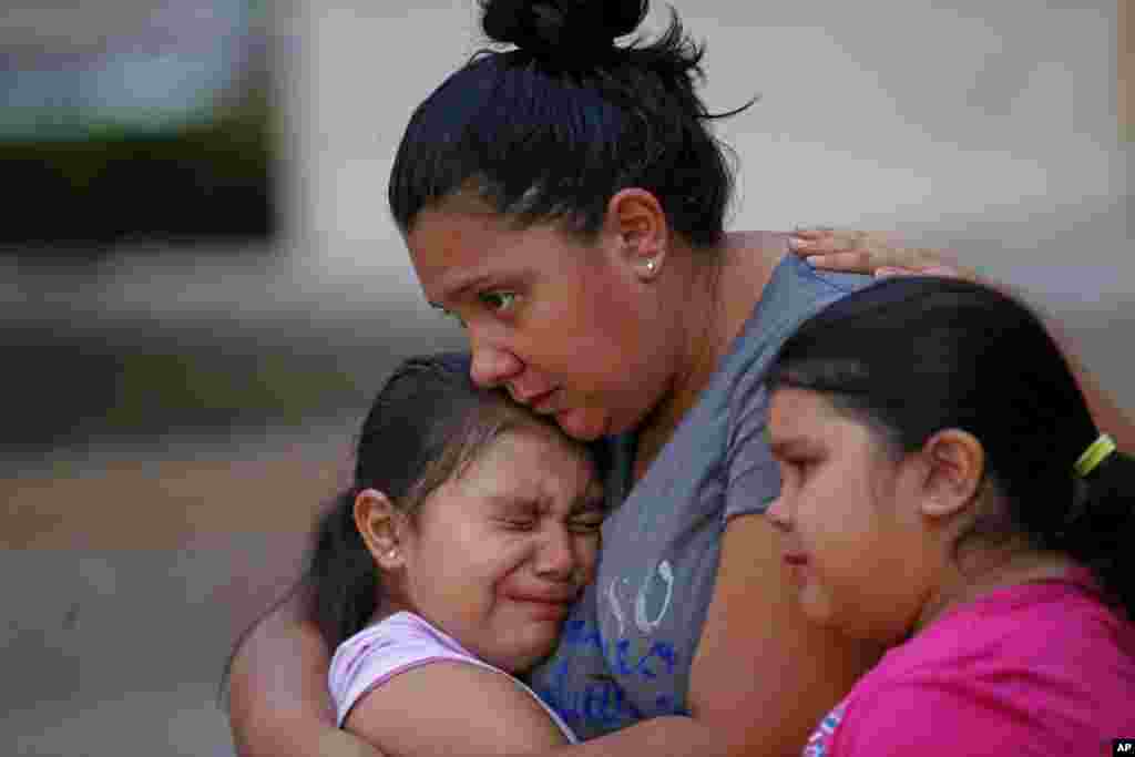 Crystal Delgado comforts her children Brielle, 8, and Dasani, 10, as they cry at a makeshift memorial in honor of the slain Dallas police officers in front of police headquarters in Dallas, Texas, July 9, 2016.