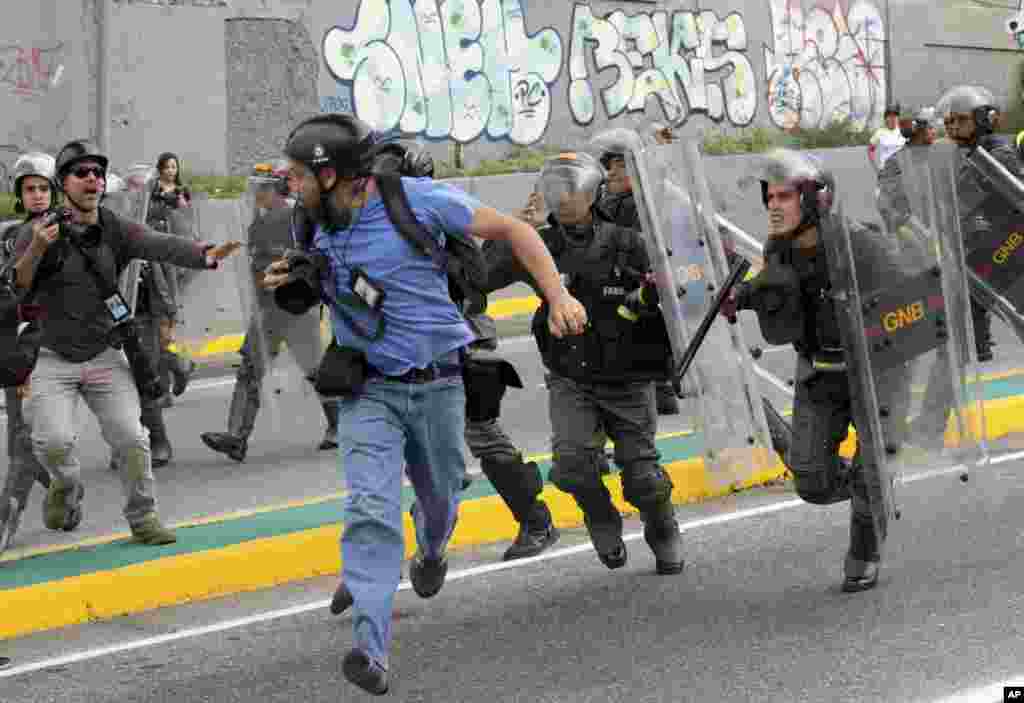 Reuters photojournalist Marco Bello runs as Venezuelan National Guard soldiers chase him during a protest outside the Supreme Court in Caracas, Venezuela, March 31, 2017.