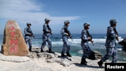 FILE - Soldiers of China's People's Liberation Army (PLA) Navy patrol at Woody Island, in the Paracel Archipelago in the South China Sea, Jan. 29, 2016. 