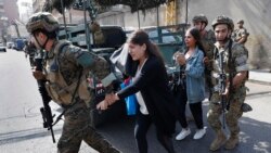  Lebanese army Special Forces soldiers assist teachers as they flee their school after deadly clashes erupted nearby along a former 1975-90 civil war front-line between Muslim Shiite and Christian areas at Ain el-Remaneh neighborhood, in Beirut, Lebanon, Oct. 14, 2021.