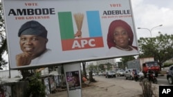 Traffic passes a billboard promoting the campaign of Lagos state governorship candidate Akinwunmi Ambode on a street in Lagos, Nigeria, April 10, 2015.