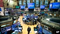 Seorang pedagang berjalan di lantai Bursa Efek New York selama pidato Presiden Donald Trump dari Gedung Putih, di New York, 13 Maret 2020. (Foto: AP)