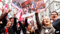 Supporters of Socialist Party candidate for the presidential election Francois Hollande celebrate with champagne after the first results of the second round of French presidential elections outside Socialist Party campaign headquarters in Paris, France, S