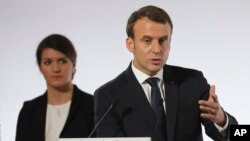 French President Emmanuel Macron delivers his speech as French Junior Minister for Gender Equality Marlene Schiappa, left, listens, during a ceremony marking the International Day for the Elimination of Violence Against Women, Saturday Nov. 25, 2017 at the Elysee Palace in Paris.
