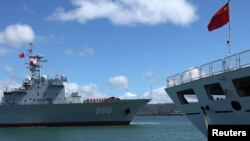 FILE - China’s replenishment ship, Qiandaohu, left, sails past its hospital ship, Peace Ark, as it docks in Honolulu, Hawaii. 