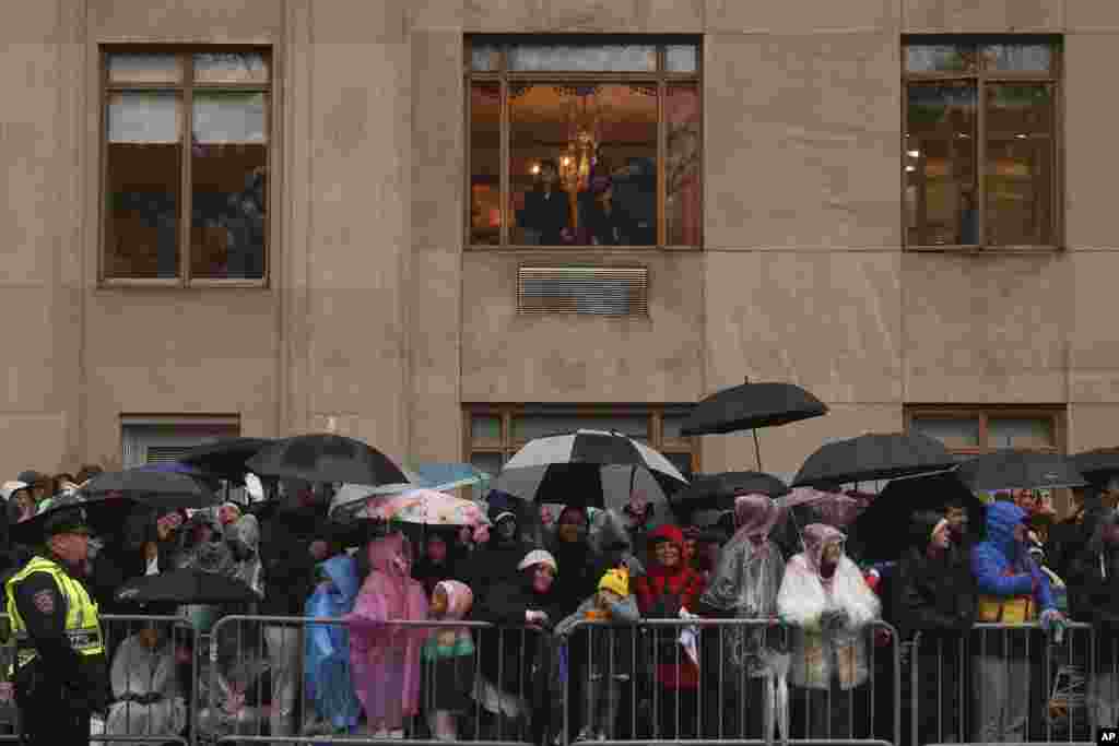 Spectators watch in the rain as the Macy's Thanksgiving Day Parade travels down Central Park West, Nov. 28, 2024, in New York. 