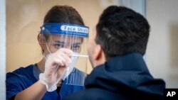 Prema podacima Univerziteta Džons Hopkins - u Sjedinjenim Državama potvrđeni slučajevi približavaju se brojci od sedam miliona i sedam stotina hiljada. Od posledica koronavirusa preminulo je skoro 214.000 ljudi. (Foto: Kay Nietfeld/dpa via AP)