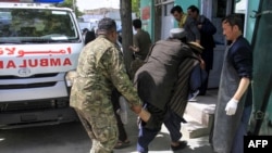 Afghan security personnel and voluntaries carry an injured man to a hospital following a suicide bomber attack with explosives packed in a vehicle in Ghazni province on May 22, 2019. 