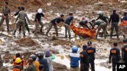 Masu aikin ceto suke zakulo gawar wani da gocewar laka ta halaka.