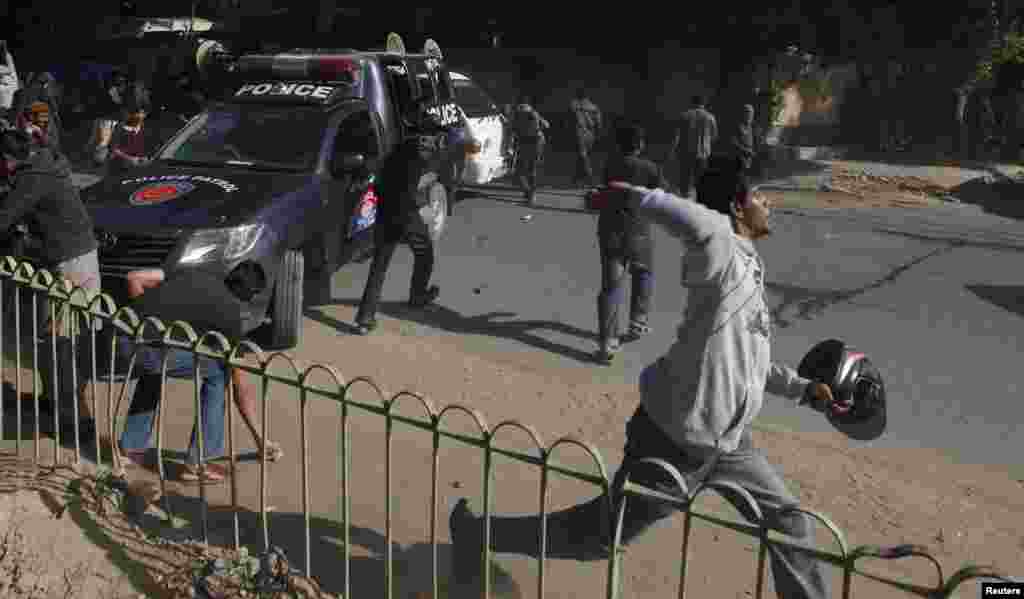 Supporters of Jamiat Talaba Islam (JTI), the student wing of Jamat Islami (JI), throws stones at policemen during a protest against satirical French weekly Charlie Hebdo, which featured a cartoon of the Prophet Muhammad on its cover after the Paris terror attack, Karachi, Pakistan, Jan. 16, 2015. &nbsp;&nbsp;&nbsp;