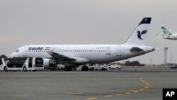 FILE - An Iranian Mahan Air passenger plane takes off as a plane of Iran's national air carrier, Iran Air, is parked at left, at Mehrabad airport in Tehran, Feb. 7, 2016.