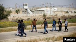 African migrants walk on a road after being released from Saharonim Prison in the Negev desert, Israel, April 15, 2018. 