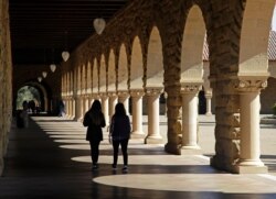 FILE- In this March 14, 2019, file photo students walk on the Stanford University campus in Santa Clara, Calif. A trade war between the United States and China could reportedly cost American universities up to $1.15 billion in lost tuition revenue.