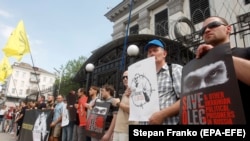 UKRAINE -- Activists holds posters with images of Ukrainian film director Oleh Sentsov, during a rally in support of Sentsov and other Ukrainian political prisoners jailed in Russia, in front of the Russian embassy in Kyiv, June 13, 2018