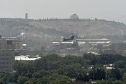 FILE - A US military helicopter is pictured flying above the US Embassy in Kabul on Aug. 15, 2021. (Photo by Wakil Kohsar/ AFP)