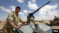 Seorang tentara pemberontak Libya siaga dengan senjata mesin.