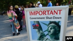 Turisti u Njujorku prolaze pored znaka da je Statua slobode zatvorena zbog zatvaranja vlade. 