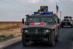 FILE - Russian forces patrol near the city of Qamishli, north Syria, Oct. 24, 2019.