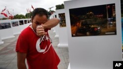 Savas Altay weeps as he visits an outdoor exhibition featuring photographs of July 15, 2016, coup attempt, in Istanbul, July 14, 2017. Turkey commemorates the anniversary with events honoring about 250 people who were killed while trying to oppose coup-plotters.
