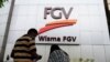 A couple talks outside FGV Holdings Berhad, one of Malaysia's largest palm oil companies, in Kuala Lumpur, Oct. 1, 2020. 