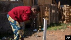 A boy brushes his teeth from a communal faucet in the Jardim Julieta squatter camp in Sao Paulo, Brazil, July 23, 2020.