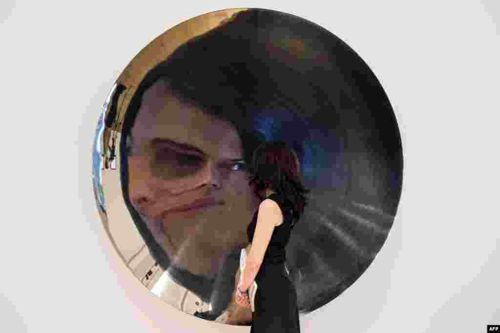 Karyawan rumah lelang Bonham&#39;s meneliti sebuah patung stainless steel karya Anish Kapoor dalam acara tinjauan pers di London menjelang penjualan karya seni kontemporer dan pasca masa perang tanggal 2 Juli. Nilai patung itu ditaksir antara USD $765,000-1,105,000. &nbsp; 