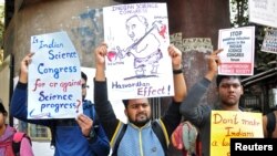 Orang-orang mengangkat poster untuk berunjuk rasa menentang klaim yang dibuat para pembicara yang mendiskreditkan teori yang dikemukakan oleh Isaac Newton dan Albert Einstein, pada Kongres Sains India ke-106 di Kolkata, India, 7 Januari 2019 (foto: Reuters/Stringer)