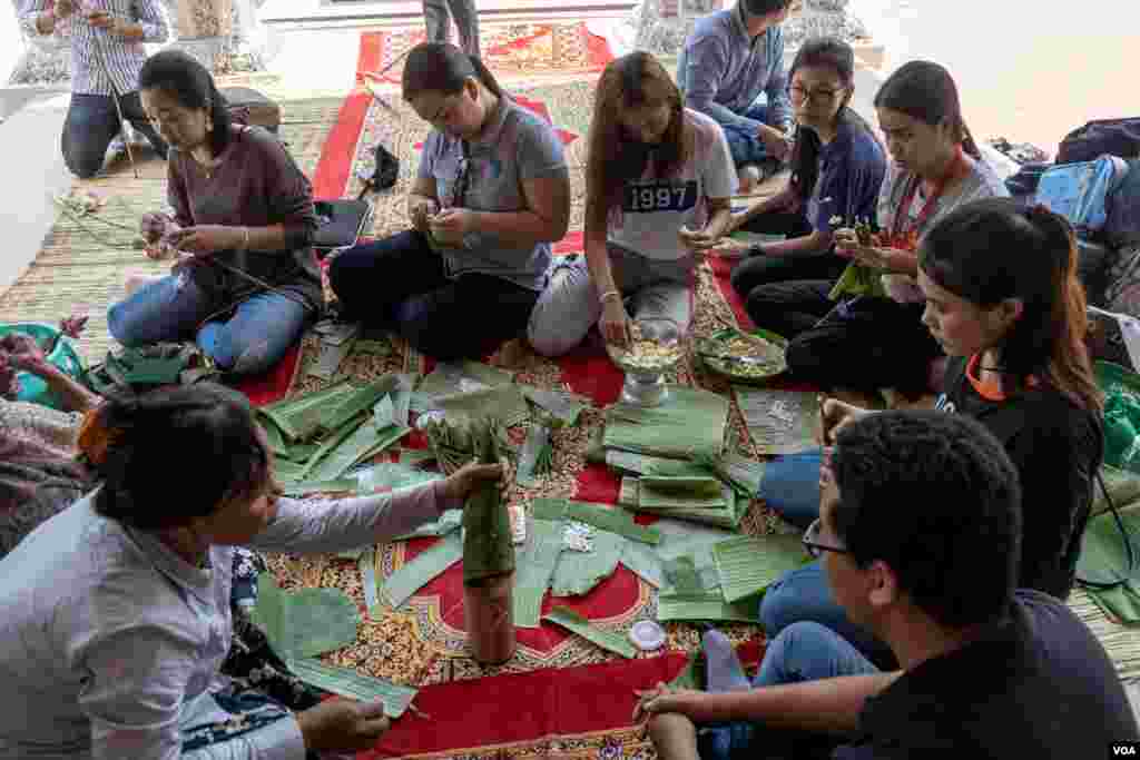 ក្រុម​យុវជន​រៀន​កាច់ផ្កា​ឈូក ធ្វើ​បាយ​សី​ ក្រងភួងផ្កាម្លិះ​ រៀបចំ​កន្ទង​តង្វាយ​ និងធ្វើប្រទីបតូច​ៗបណ្តែតទឹកពី​ចាស់ៗ​ដែល​មានជំនាញ នៅក្នុងកម្មវិធី​ «បុណ្យភូមិ», នៅរាជ​ធានីភ្នំពេញ, នៅថ្ងៃទី០៦ ខែមេសា ឆ្នាំ២០១៩។ (ខាន់ សុគុំមនោ/VOA)