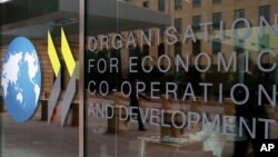The logo at the entrance of the Organisation for Economic Co-operation and Development (OECD) headquarters in Paris, France, Wednesday, June 7, 2017. (AP Photo/Francois Mori)