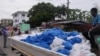 As part of measures by the Ghanaian government, food packages are distributed by members of a church to households in Ghana's capital Accra. (Stacey Knott/VOA)