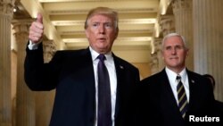 U.S. President Donald Trump gives a thumbs-up as he and Vice President Mike Pence depart the U.S. Capitol after a meeting to discuss tax legislation with House Republicans, Nov. 16, 2017. 