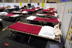 Cots are shown in a dormitory at an emergency shelter for migrant children July 2, 2021, in Pomona, Calif.