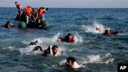 Des migrants finissent leur parcours à la nage après que leur bateau se soit renversé près de l'île de Lesbos, Grèce, le 20 septembre 2015. 