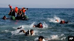 FILE - Migrants whose boat stalled at sea while crossing from Turkey to Greece swim to approach the shore of the island of Lesbos, Greece, Sept. 20, 2015.