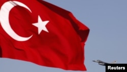 FILE - A Turkish Air Force F16 jet fighter takes off from an air base as Turkey's national flag is seen in the foreground, April 28, 2010. A top official of Turkey's state-run arms company was arrested this week for allegedly trying to sell weapons secrets.