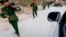 FILE - Myanmar army soldiers walk along a road near Laukkai, Feb. 17, 2015.