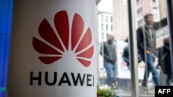 Seorang pejalan kaki melewati toko yang menjual produk Huwaei, di London, 29 April 2019.