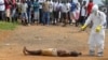 A health worker, right, sprays a man with disinfectant chemicals in Monrovia, Liberia, Sept. 4, 2014.