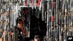 A mechanic sits working at a roadside motorcycle repair shop in downtown Hanoi, 28 Dec 2010