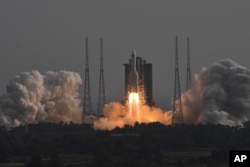 In this photo released by Xinhua News Agency, the Long March-5B Y4 carrier rocket carrying the space lab module Mengtian, blasts off from the Wenchang Satellite Launch Center in south China's Hainan Province, Monday, Oct. 31, 2022.