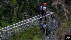 FILE - Whitefish Energy Holdings workers restore power lines damaged by Hurricane Maria in Barceloneta, Puerto Rico, Oct. 15, 2017.