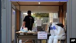 មន្ត្រី​សុខាភិបាល​ស្លៀក​ឈុត​ការពារ​ខ្លួន​អង្គុយ​សម្រាក​អំឡុង​ពេល​ការ​ធ្វើ​តេស្តរក​ជំងឺ​កូវីដ​១៩​នៅ​មជ្ឈមណ្ឌល​សុខាភិបាល​សាធារណៈក្នុង​ទីក្រុង Goyang ប្រទេស​កូរ៉េខាងត្បូង​កាលពី​ថ្ងៃទី​២៨ ខែឧសភា ឆ្នាំ២០២០។