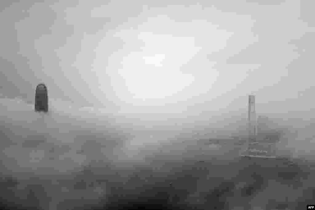 Gedung IFC (kiri) dan ICC (kanan) tampak diselimuti kabut di Hong Kong pada 16 Maret 2015. Cuaca berkabut di kota China selatan tersebut disebabkan oleh aliran udara maritim yang lembab yang mempengaruhi wilayah pesisir China selatan. (AFP PHOTO / Philippe Lopez)