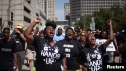 Activists raise their hands as they demand justice for the killing of Michael Brown while marching to the Thomas F. Eagleton United States Courthouse from City Hall in downtown St. Louis, Missouri, Aug. 26, 2014. 