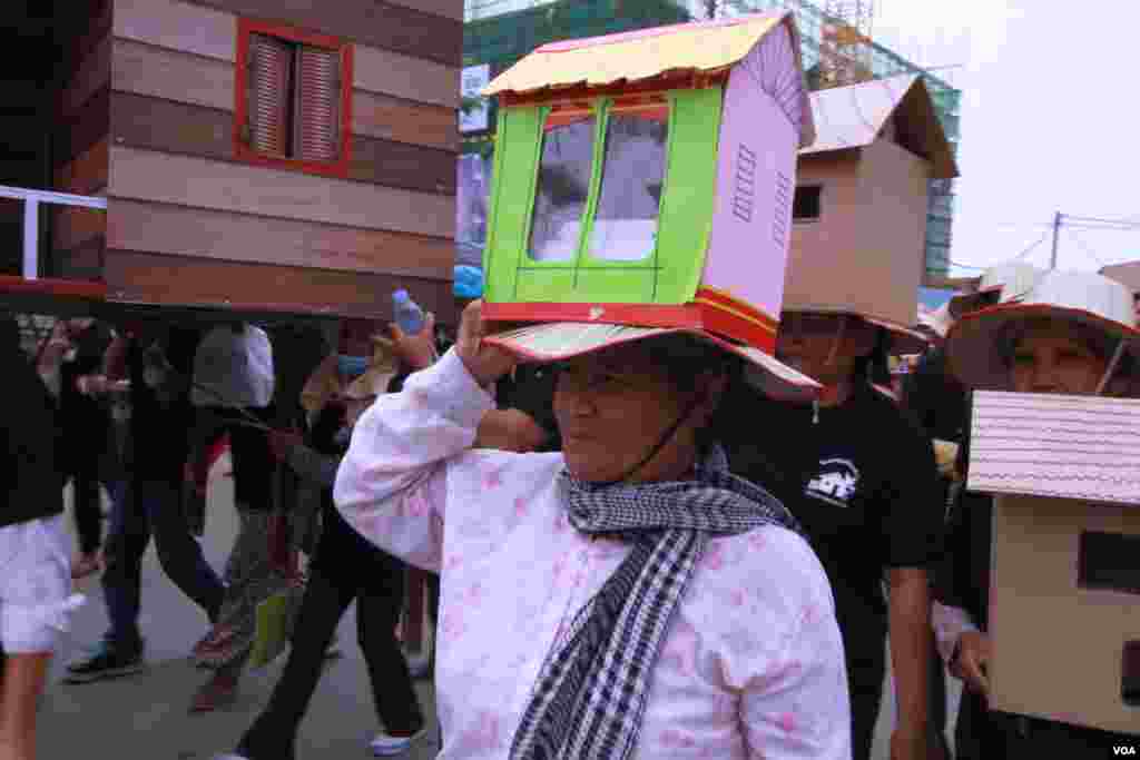 ក្រុម​អ្នក​តវ៉ា​មក​ពី​សហគមន៍​ ដែល​មាន​ជម្លោះ​ដី​ធ្លី​ប្រមាណ​១០០០​នាក់​ នៅ​ក្នុង​រាជធានី​ភ្នំពេញ​ បាន​ហែ​ញតិ្ត​ទៅ​ដាក់​រដ្ឋ​សភាជាតិ​ ក្នុង​ឱកាស​ទិវា​លំនៅដ្ឋាន​ពិភពលោក​ខួប​លើក​ទី​៣០ កាល​ពី​ថ្ងៃ​ទី​៥ ខែ​តុលា ឆ្នាំ​២០១៥។​ (ឡេង ឡែន/VOA)