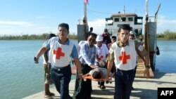 FILE - Injured people from Kyauk Tan village in Rathedaung township are carried on stretchers as they arrive in Rakhine state's capital Sittwe in western Myanmar, May 2, 2019.