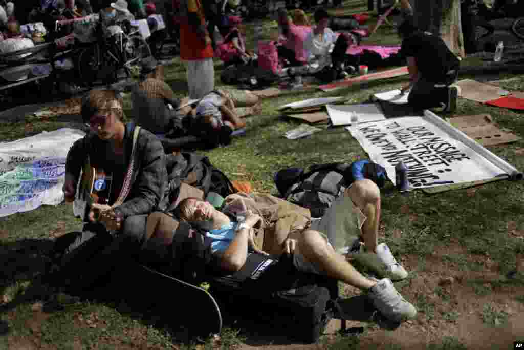 Wes Ketz relaxes in the sun during an Occupy Wall Street anniversary concert in Foley Square in New York, September 16, 2012. 