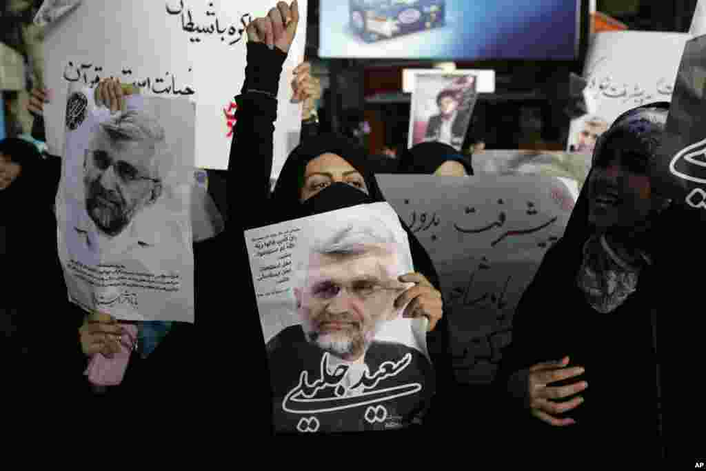 Supporters of the Iranian presidential candidate Saeed Jalili, shown in the posters, chant slogans, Tehran, Iran, June 9, 2013.