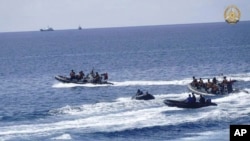 Personel angkatan laut Filipina mengumpulkan sisa-sisa paket makanan yang terapung di lautan Second Thomas Shoal, pada Minggu, 19 Mei 2024. (Foto: via AP)