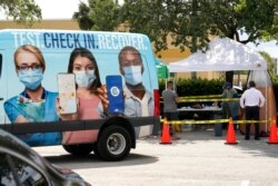 FILE - People wait in line at a COVID-19 testing site, in Hialeah, Florida, July 26, 2021.